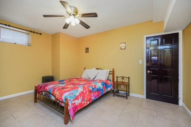 bedroom with light tile patterned floors, a ceiling fan, and baseboards