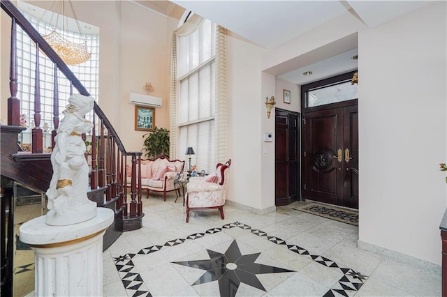 entryway featuring a healthy amount of sunlight, stairs, baseboards, and a high ceiling