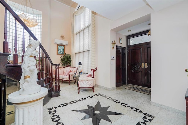 foyer entrance featuring baseboards, stairs, a notable chandelier, and a healthy amount of sunlight
