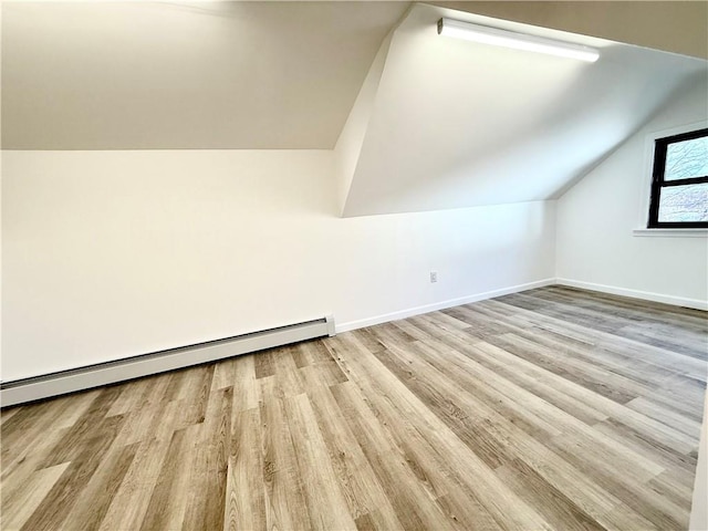 bonus room featuring a baseboard radiator, lofted ceiling, and light hardwood / wood-style floors