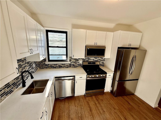 kitchen featuring white cabinetry, sink, dark hardwood / wood-style floors, and appliances with stainless steel finishes