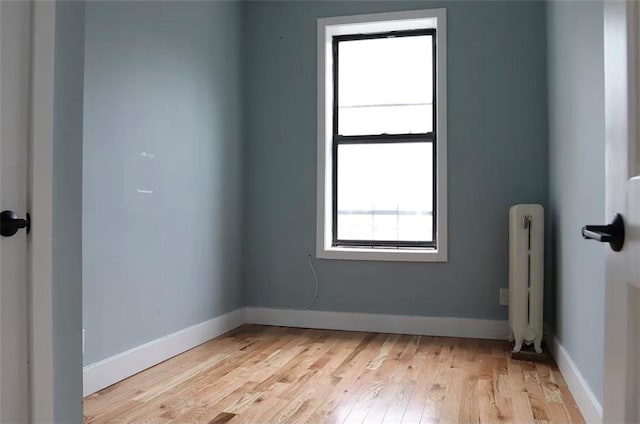 unfurnished room featuring radiator and light hardwood / wood-style floors