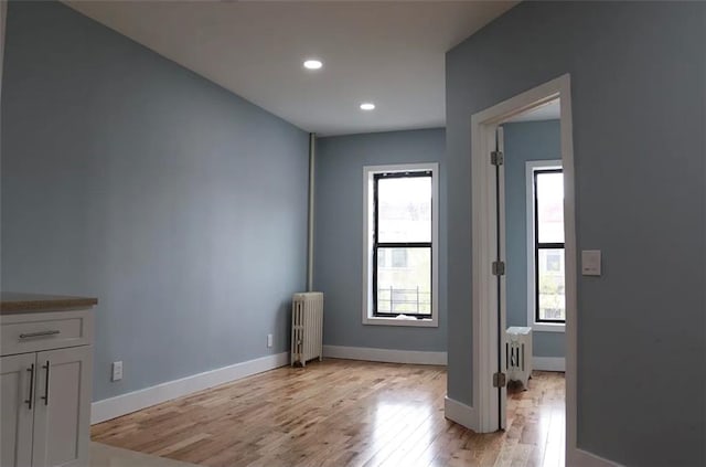 interior space with radiator heating unit and light wood-type flooring