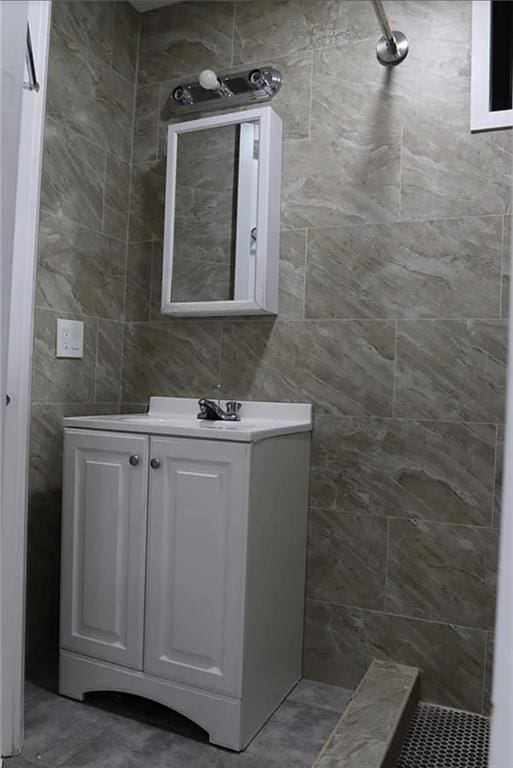 bathroom featuring vanity, tile walls, and walk in shower