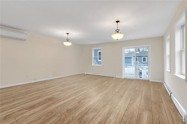 unfurnished room with a baseboard radiator, a wall mounted air conditioner, and light hardwood / wood-style floors