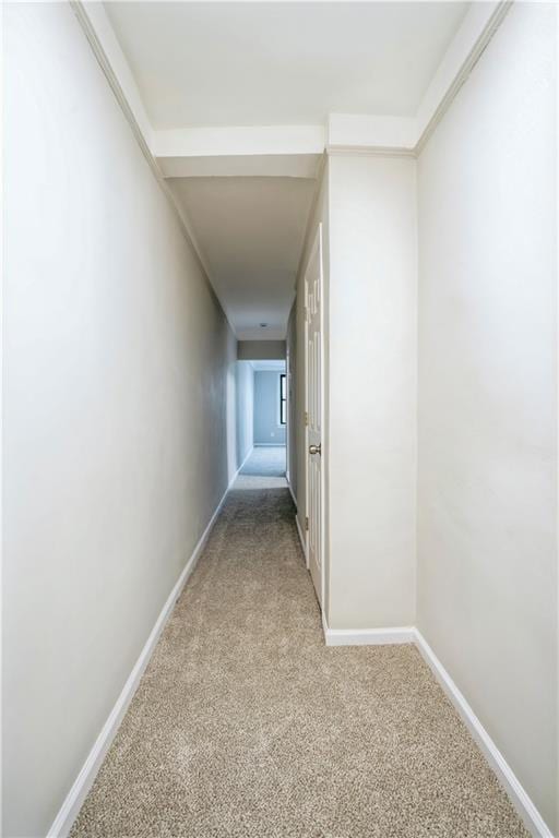 hallway with light carpet and baseboards