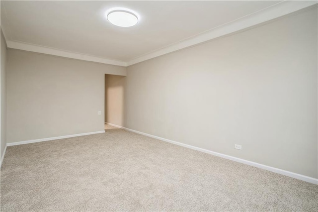 unfurnished room featuring carpet floors, crown molding, and baseboards