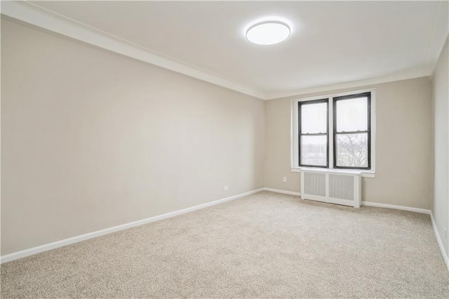 unfurnished room with radiator heating unit, baseboards, and light colored carpet