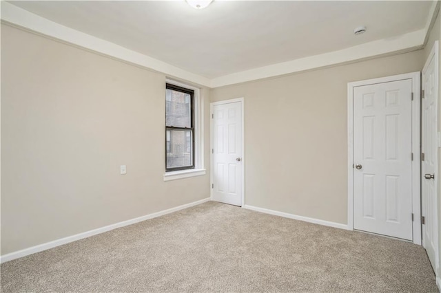 unfurnished room with carpet and baseboards