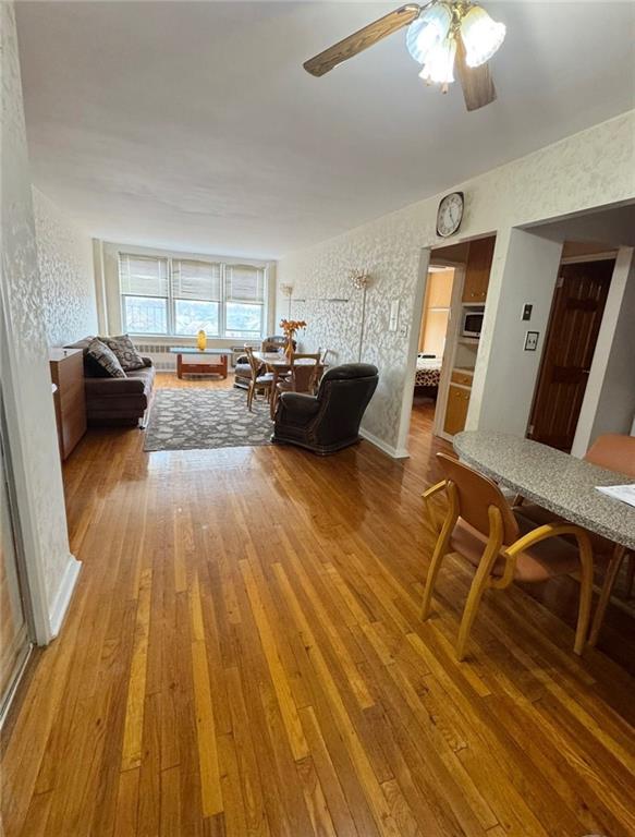 living room featuring hardwood / wood-style floors and ceiling fan