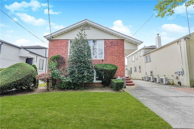 view of front facade featuring a front yard and brick siding