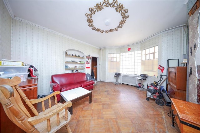 sitting room with radiator heating unit, ornamental molding, and light parquet flooring