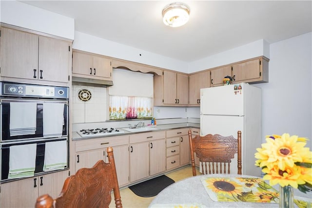 kitchen with sink, light brown cabinetry, and white appliances