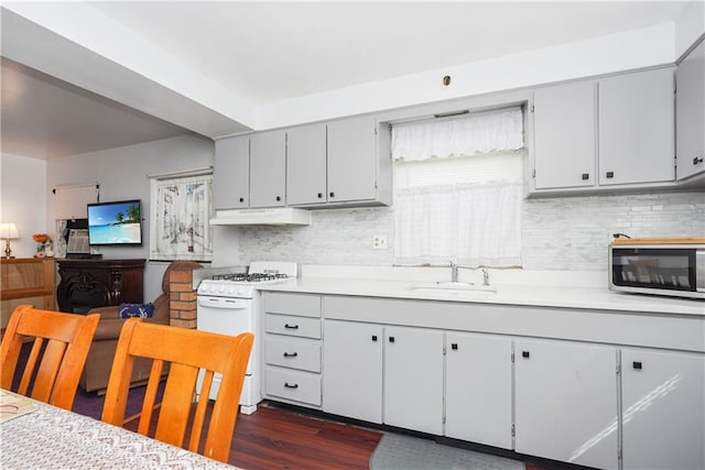 kitchen featuring tasteful backsplash, dark wood-type flooring, sink, and gas range gas stove