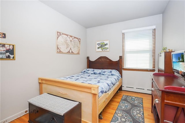 bedroom with baseboard heating and light wood-type flooring