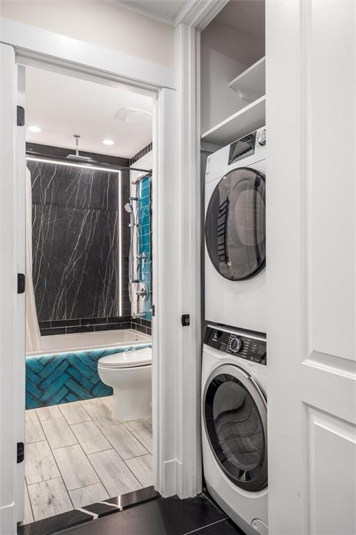 washroom with stacked washer and dryer and laundry area