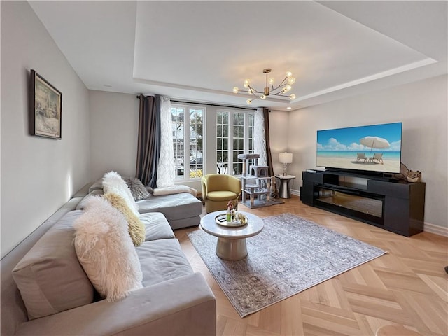 4912 Surf Ave, Brooklyn, NY 11224 - living area featuring baseboards, a tray ceiling, and a notable chandelier