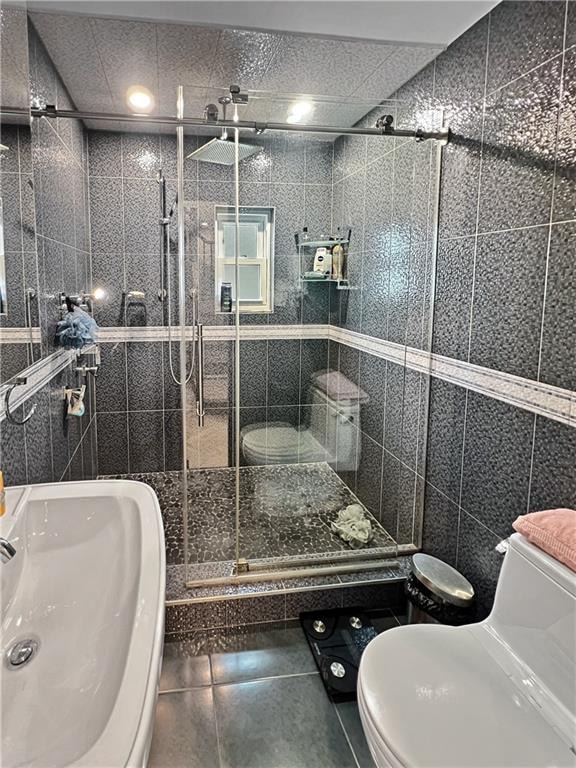 4912 Surf Ave, Brooklyn, NY 11224 - bathroom featuring toilet, a stall shower, and tile walls