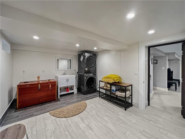 4912 Surf Ave, Brooklyn, NY 11224 - laundry area featuring a sink, wood tiled floor, stacked washer and clothes dryer, laundry area, and baseboards