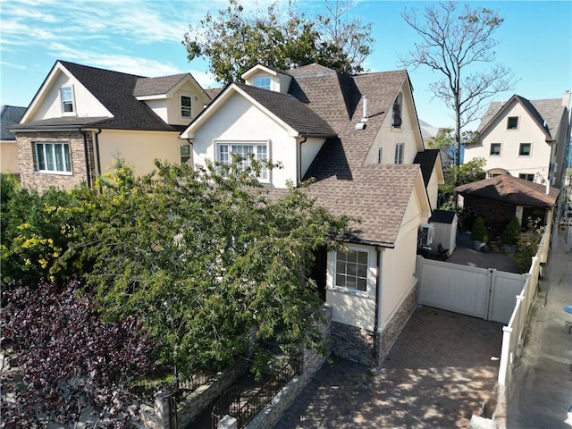 4912 Surf Ave, Brooklyn, NY 11224 - view of front facade with fence, a shingled roof, a residential view, and stucco siding