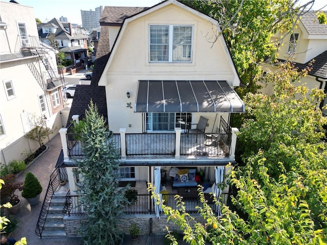 4912 Surf Ave, Brooklyn, NY 11224 - back of property featuring a standing seam roof, stucco siding, and roof with shingles