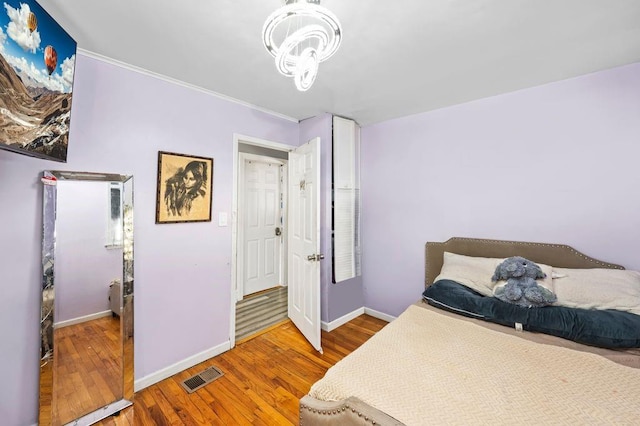 bedroom featuring hardwood / wood-style flooring and a chandelier