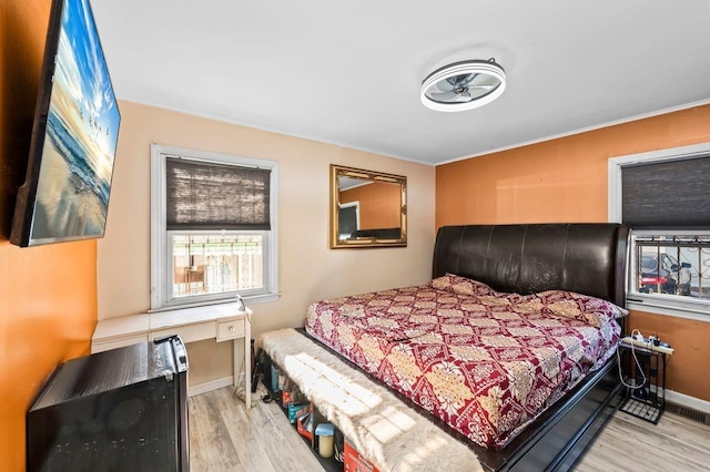 bedroom with crown molding and light wood-type flooring