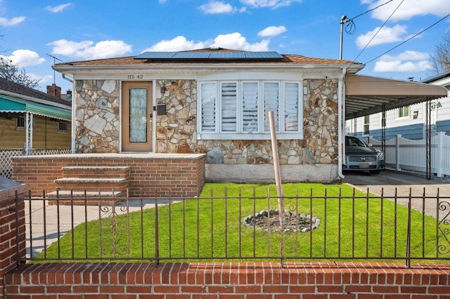 view of front of property with a front yard and solar panels