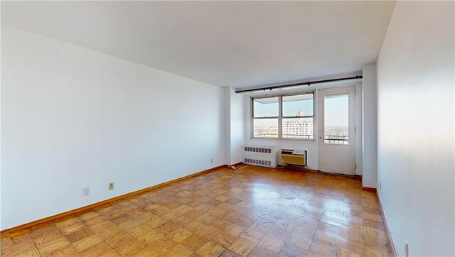 empty room featuring radiator heating unit and light parquet flooring