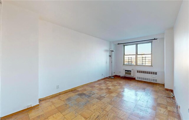 empty room with a wall mounted air conditioner and radiator