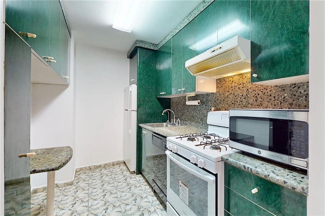 kitchen featuring white appliances, decorative backsplash, under cabinet range hood, green cabinets, and a sink