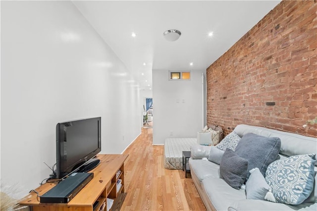 living room with light wood-type flooring and brick wall