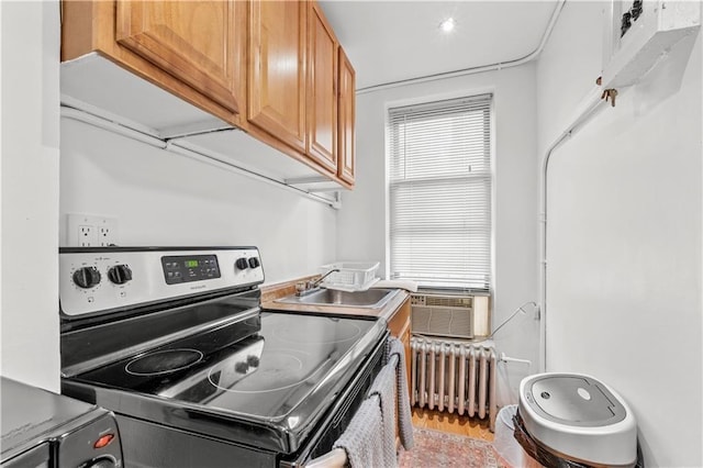 kitchen with sink, radiator heating unit, cooling unit, and stainless steel range with electric stovetop