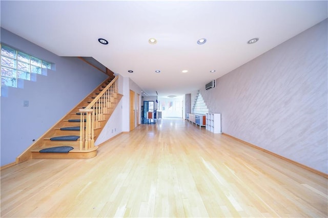 unfurnished living room with baseboards, stairway, wood finished floors, and recessed lighting