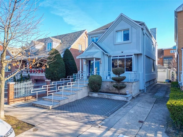 view of front of house featuring stucco siding, driveway, and fence