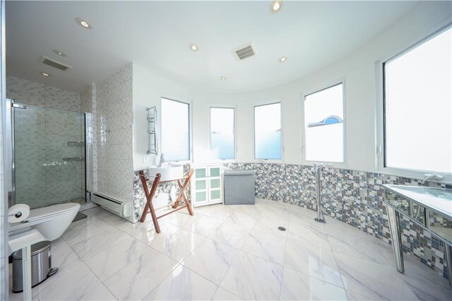 bathroom featuring toilet, sink, tile walls, a tile shower, and a baseboard radiator