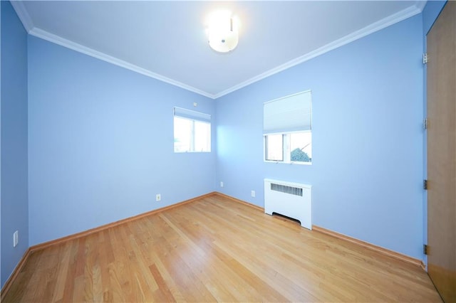 unfurnished room with crown molding, radiator heating unit, and light wood-type flooring