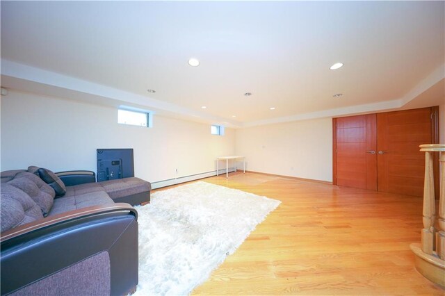 living room featuring a baseboard heating unit and light wood-type flooring