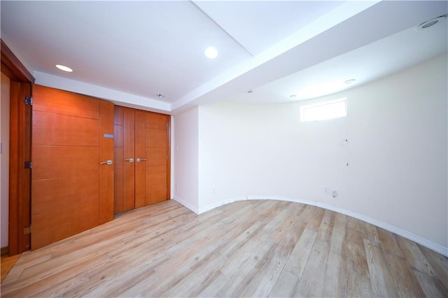 below grade area with light wood-style floors, baseboards, and recessed lighting