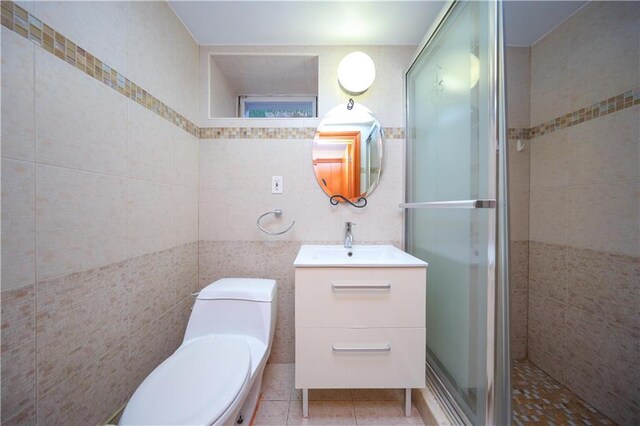 bathroom featuring tile patterned floors, toilet, an enclosed shower, tile walls, and vanity