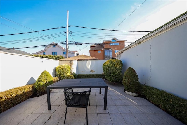 view of patio / terrace with fence, an outbuilding, and outdoor dining space