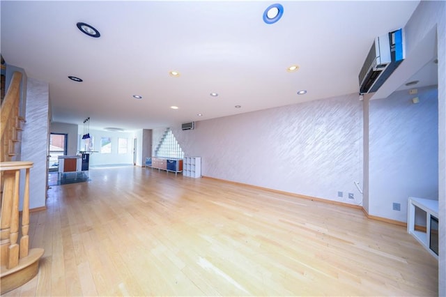 unfurnished living room featuring stairs, wood finished floors, and recessed lighting