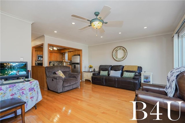 living room with crown molding, ceiling fan, and light hardwood / wood-style floors