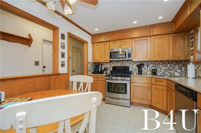 kitchen featuring light stone counters, sink, backsplash, and stainless steel appliances