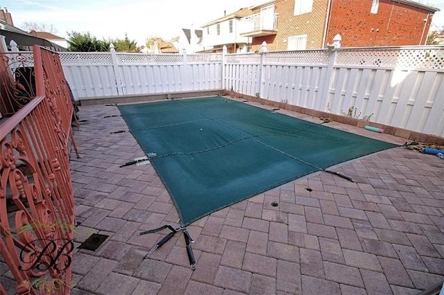 view of swimming pool with a fenced backyard and a patio