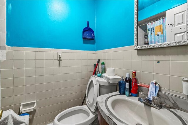 bathroom with tile walls, sink, and toilet