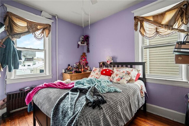 bedroom featuring radiator, dark wood-type flooring, and ceiling fan