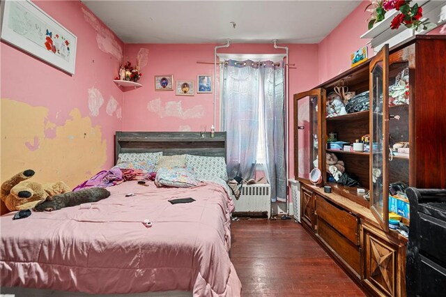 bedroom featuring dark wood-type flooring and radiator heating unit