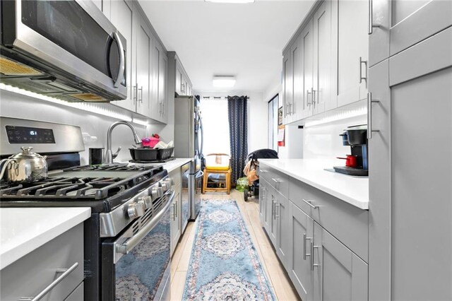 kitchen with gray cabinetry and stainless steel appliances