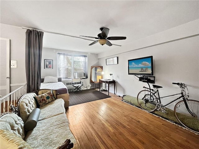 living room featuring cooling unit, hardwood / wood-style floors, and ceiling fan